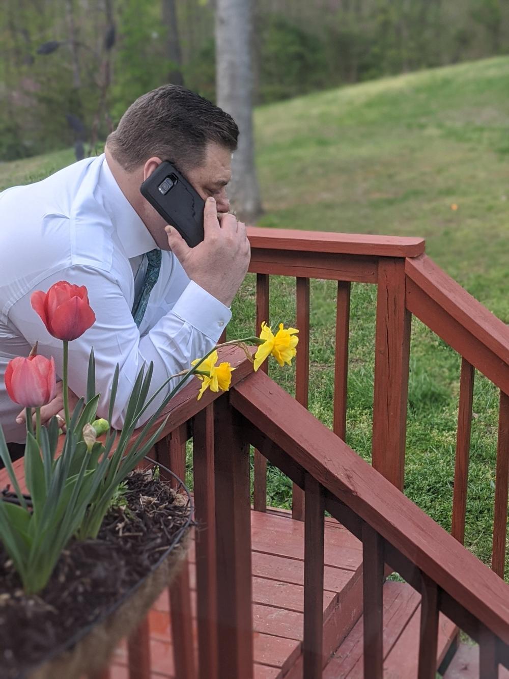 man talking on cell phone with red tulips in foreground