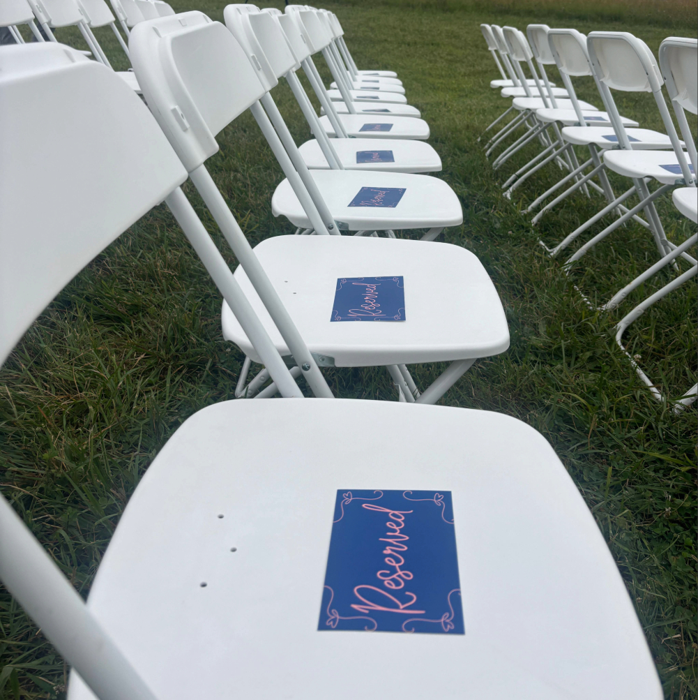 white wedding chairs with reserved signs outdoor