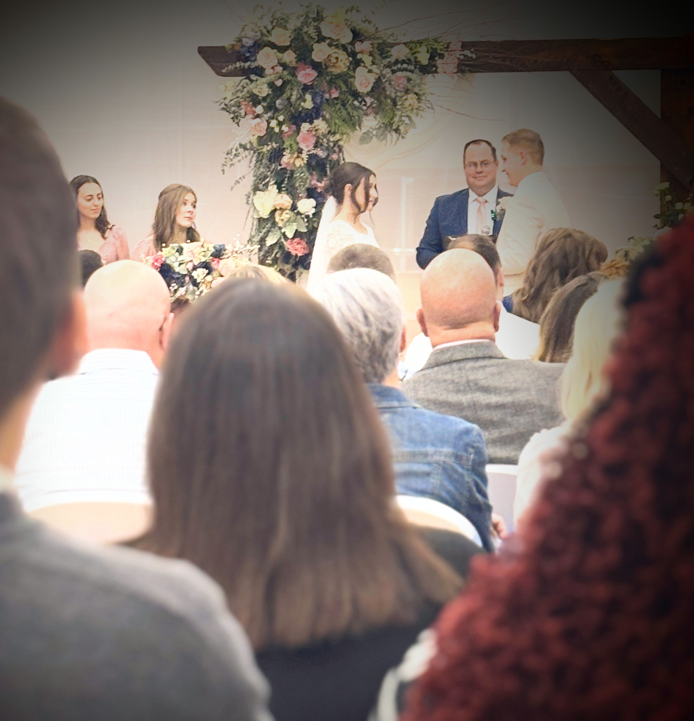 wedding ceremony with floral arch